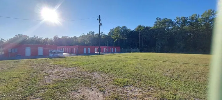 row of self storage units with drive up with fence