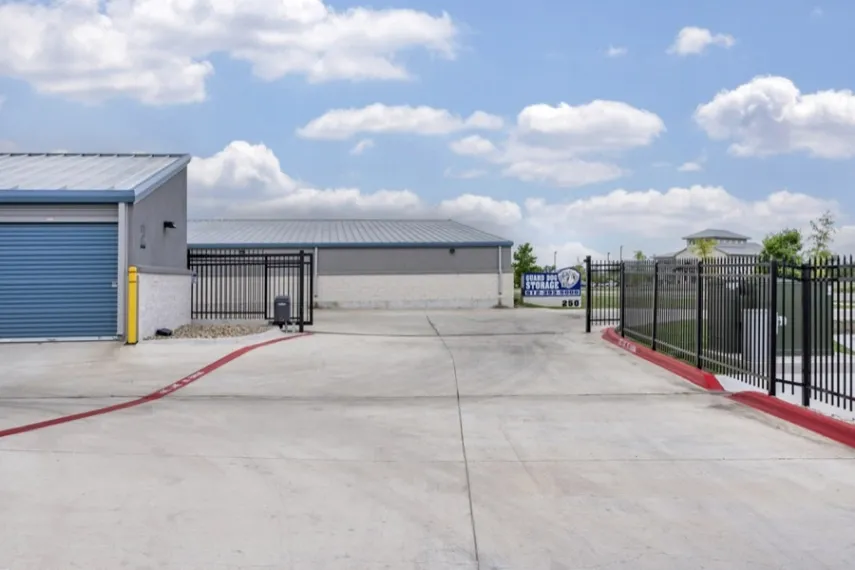 Gated entrance and concrete driveway to a self storage facility.