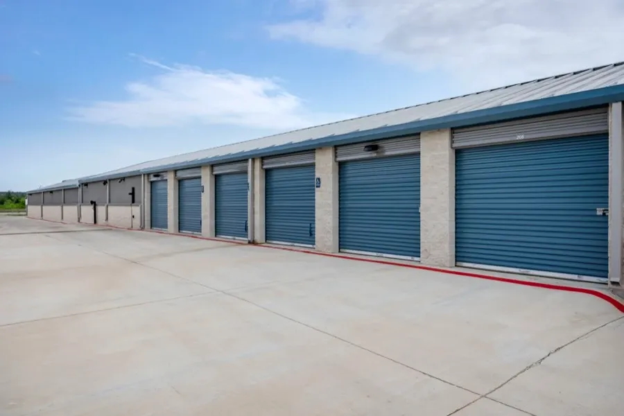 Outside of drive up self storage units with blue doors.