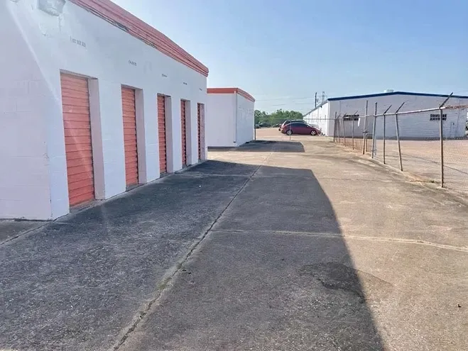 row of self storage units with drive up fenced around