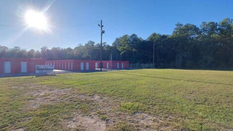 row of self storage units with drive up with fence