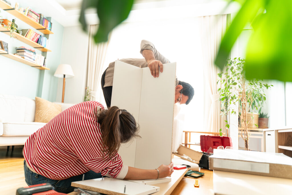 A couple assembles furniture for their space-saving efforts.