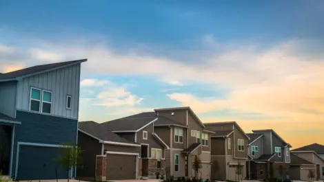 A sunset shines on a row of modern suburban homes in Austin, TX.