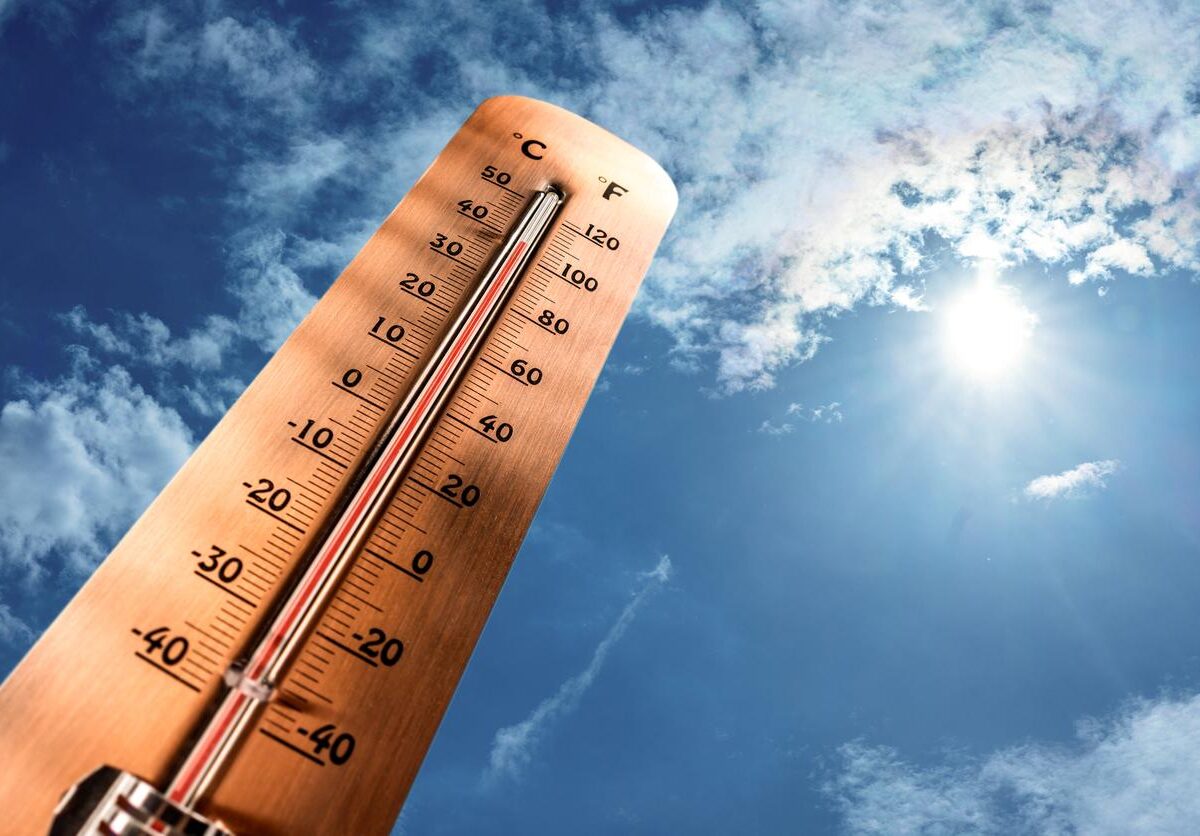 A wooden thermometer measures the temperature in Celsius and Fahrenheit to show extreme heat.