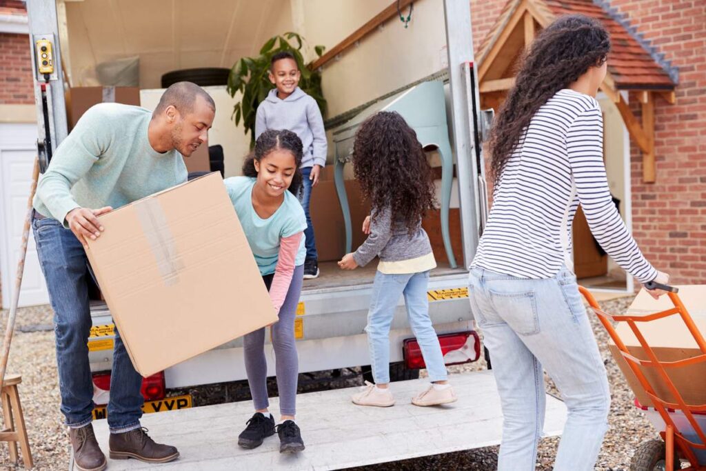 A family unloads furniture from a moving truck as they load up their new house.